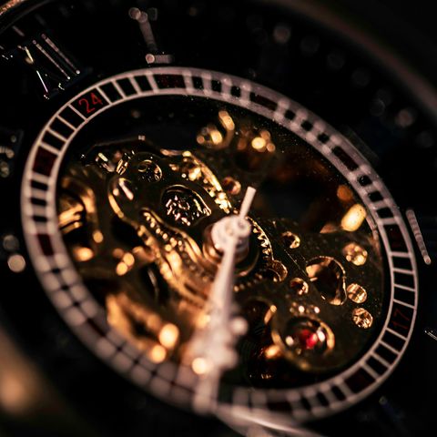 Close-up of a skeleton watch dial, with the gold movement showing through